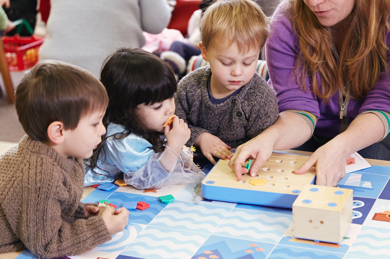 niños aprendiendo a programar en la escuela con robot Cubetto